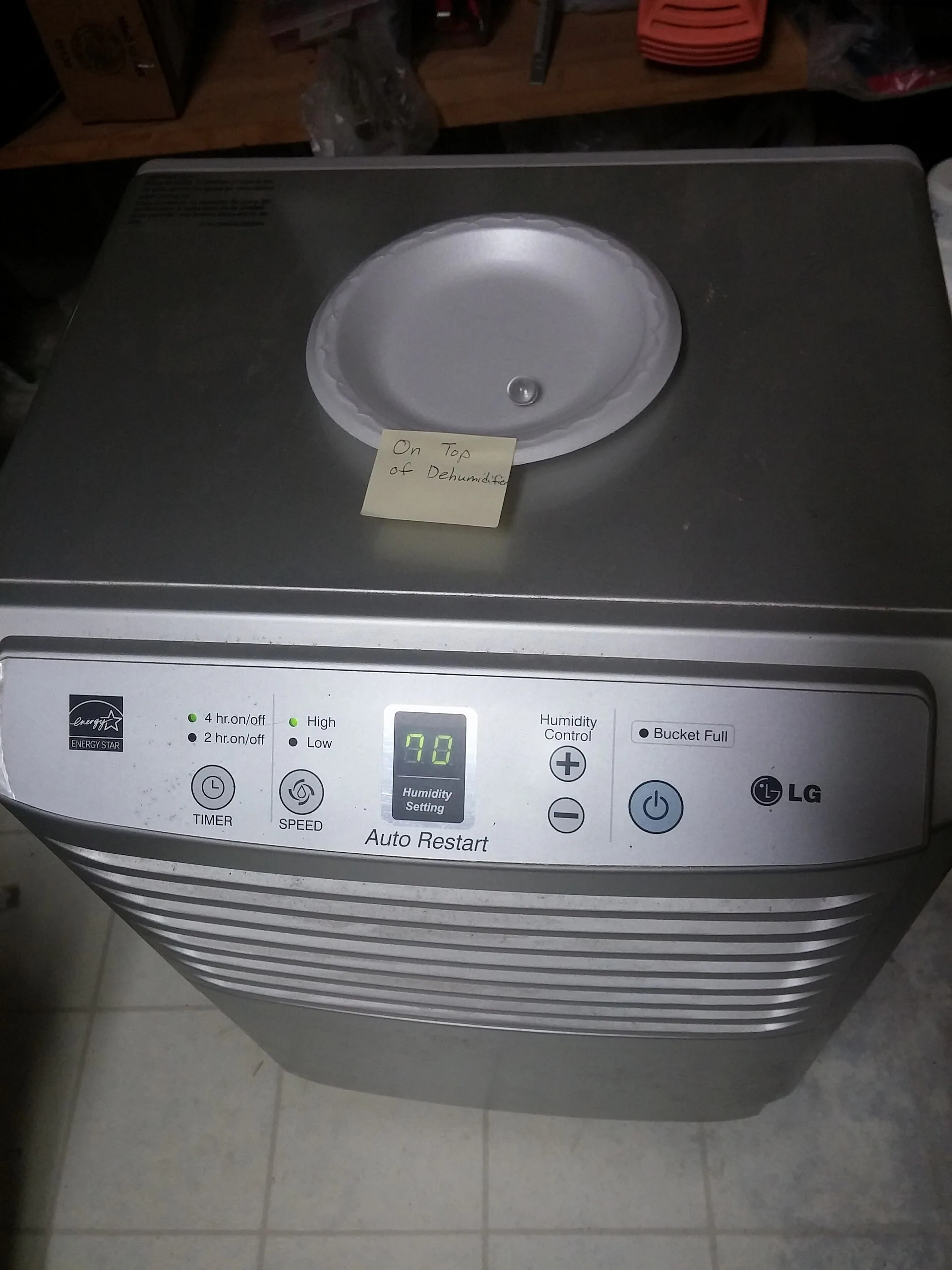 真實地下室中的 LG 除濕機，示意機器應放在平坦乾燥區並保留進出風與倒水空間