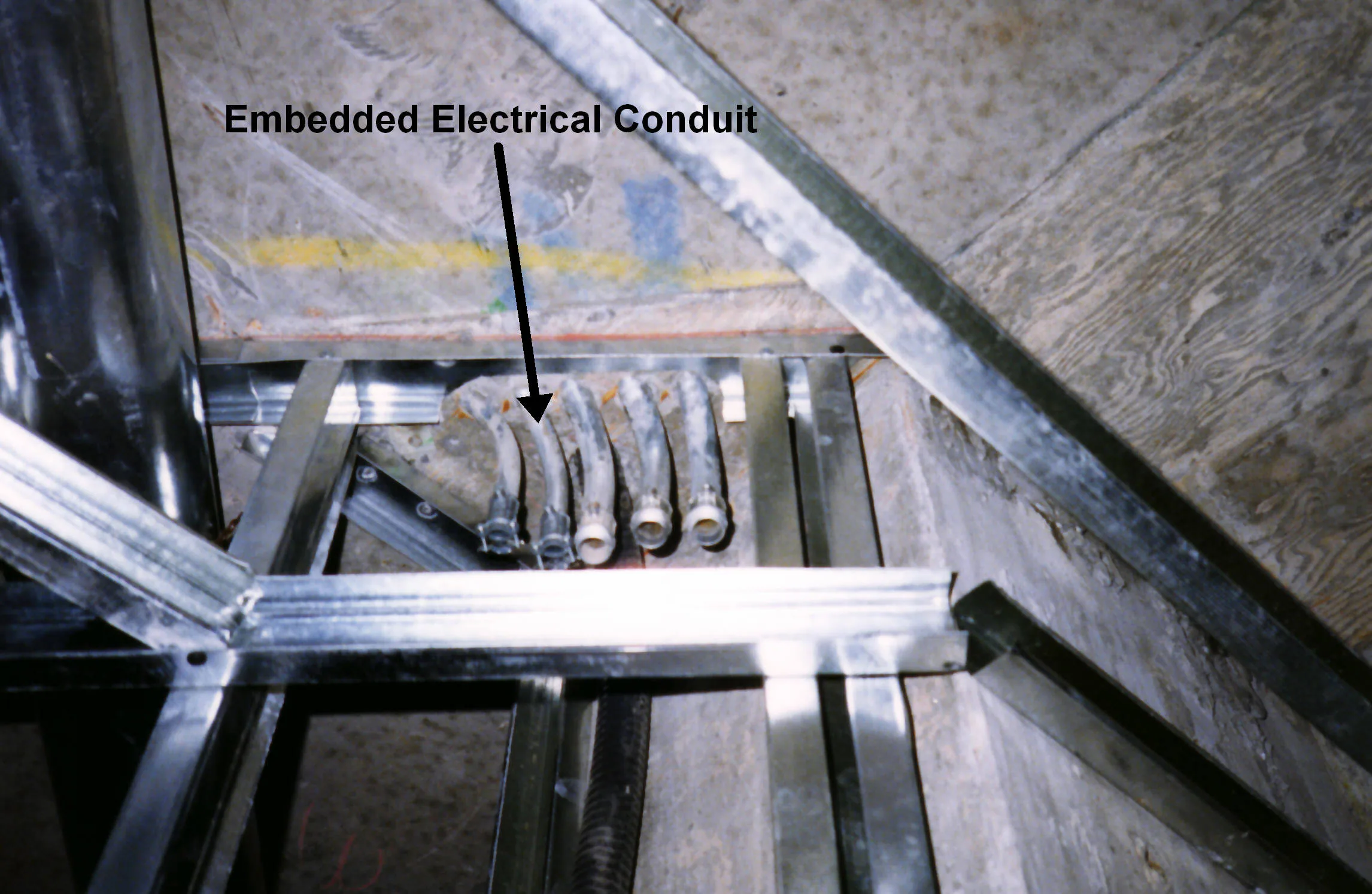 真實建築施工照片，示意混凝土與牆體內可能預埋電氣管路；照片不是台灣住宅管線位置範本